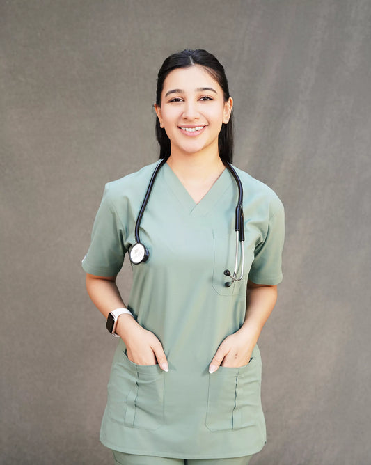 Smiling female healthcare professional wearing a sage green Medfit scrub top, ideal for comfort and durability in medical settings.
