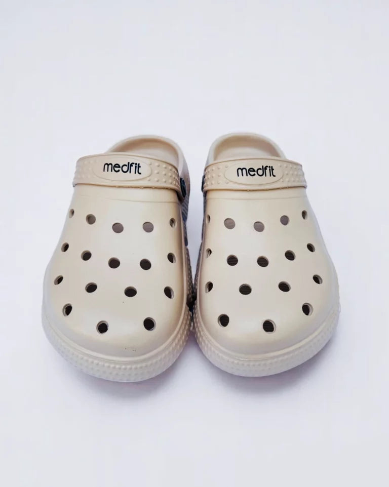 Beige clogs with black dots on a white background