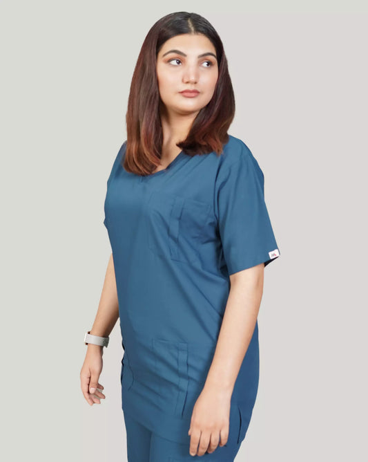 Close-up of a female medical professional in a blue 'Zinc' Medfit unisex scrub top, looking confidently off-camera, ideal for a professional healthcare uniform.