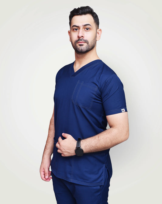 Man wearing a navy blue scrub set against a plain background