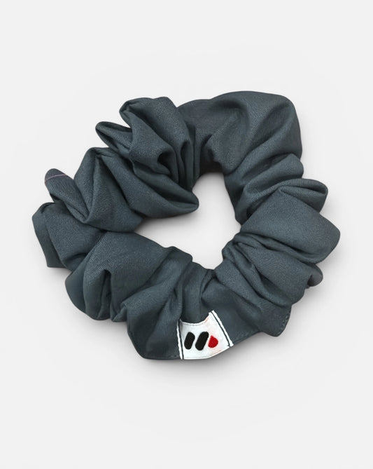 Gray scrunchie with a brand logo on a white background