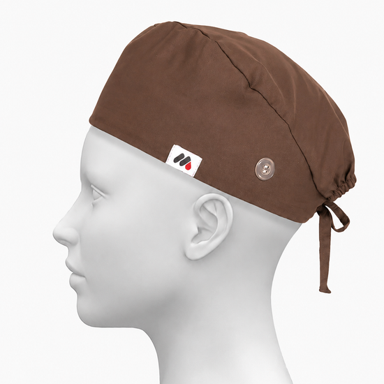 A brown surgical scrub cap with side buttons for face masks worn on a white mannequin head against a neutral gray background.