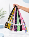 A hand holding a diverse collection of colorful printed neck lanyards and matching ID badge card holders by MedFit.
