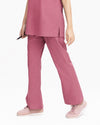 A close-up view of a healthcare professional wearing dusty rose pink medical scrub pants and matching light pink sneakers against a white background.