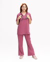 A healthcare professional modeling a matching two-piece medical scrub set in dusty rose pink, featuring a short-sleeve V-neck top and straight-leg pants against a white background.