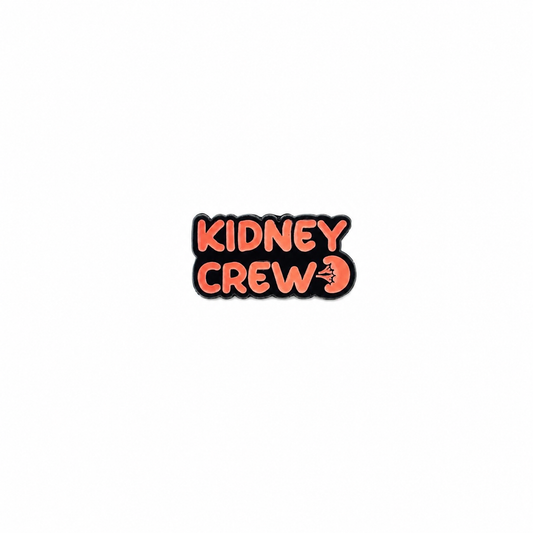 An enamel lapel pin featuring the text "KIDNEY CREW" in bold orange lettering with a small anatomical kidney graphic against a white background.