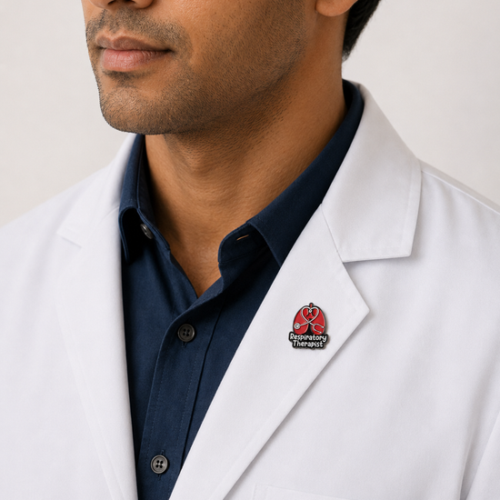 A close-up of a male healthcare professional wearing a white lab coat over a dark blue collared shirt with a respiratory therapist enamel lapel pin against a plain background.