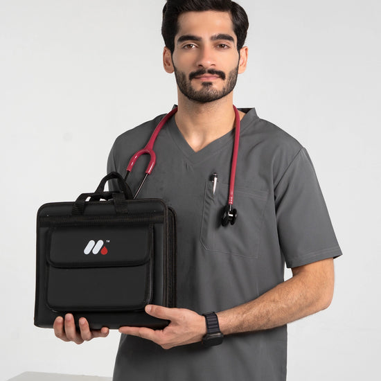 A male model wearing gray medical scrubs and a red stethoscope, holding a black medical supply and organizer bag from MedFit.