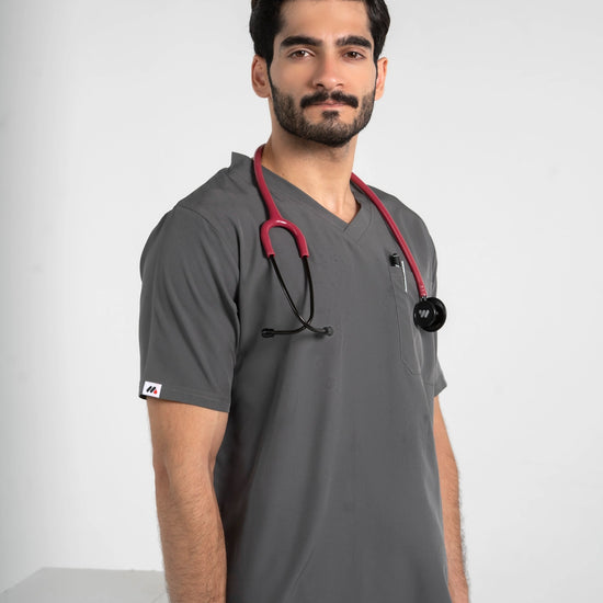 Close-up of a male model wearing a dark gray V-neck medical scrub top with a red stethoscope, MedFit professional healthcare apparel.