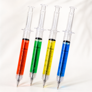 A collection of four MedFit novelty syringe-shaped ballpoint pens filled with colorful vibrant liquids on a white background.