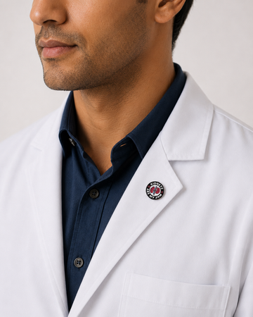 A healthcare professional wearing a crisp white lab coat styled with a unique circular logo enamel pin on the lapel.
