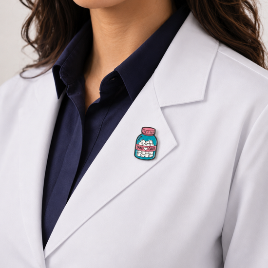 A healthcare professional wearing a crisp white lab coat styled with a unique, colorful pill bottle enamel pin on the lapel.