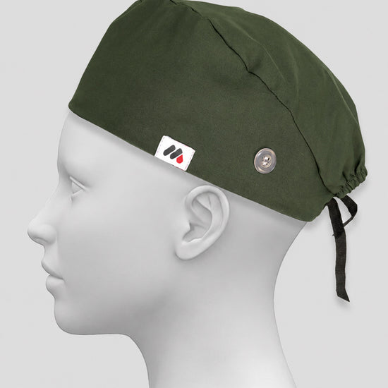 An olive green surgical scrub cap with side buttons for face masks worn on a white mannequin head against a neutral gray background.