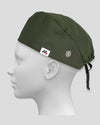 An olive green surgical scrub cap with side buttons for face masks worn on a white mannequin head against a neutral gray background.