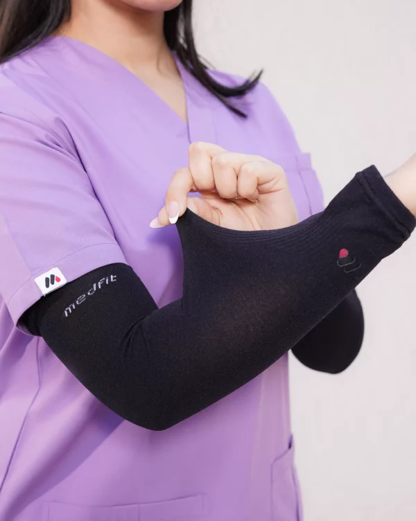 Close-up of black arm sleeve on a woman in lilac scrubs